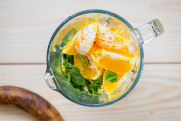 Mixed Spinach with Banana and Orange in a Blender, Smoothie Preparation Process, Top View, Free Space for Text