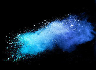 Blue powder explosion on black background.