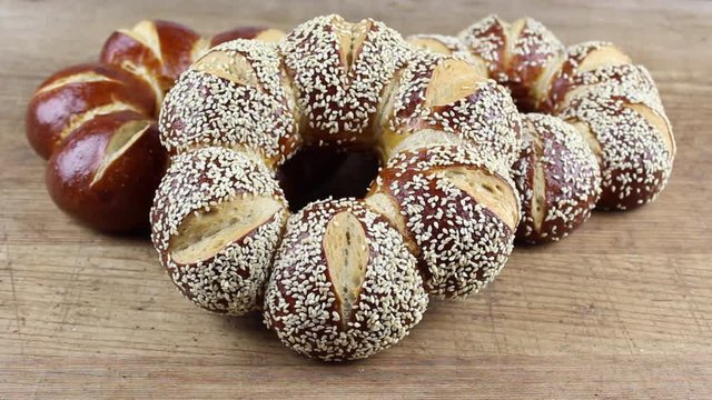 lye kringle with sesame panning on a wooden board