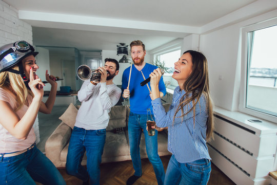 Group of friends playing karaoke at home. Concept about friendship, home entertainment and people