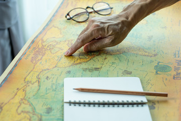 Hand pointing on America map with blank notebook