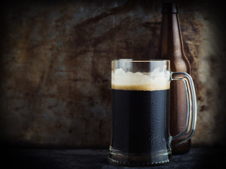 Beer mug on dark background and beer bottle with copyspace