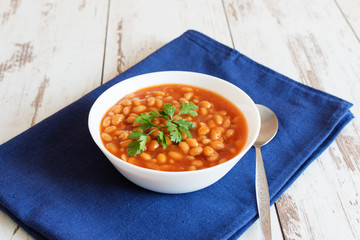 Beans in tomato sauce in a white porcelain bowl