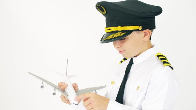 Boy wearing pilot's uniform examines airliner scale model