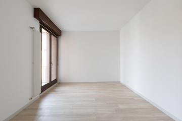 Large empty room with white walls. Parquet