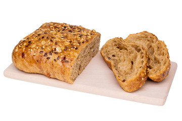 Half and two pieces of whole grain puff pastry bread with seeds of sesame, flax, sunflower on wooden coaster
