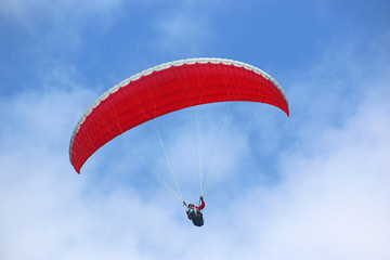 Paraglider flying wing in a blue sky