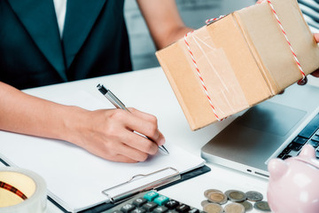 Small business concept. Woman hand with pen make a note of the product list for online shopping ...