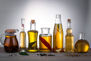 Oil in bottles with butter, olive oil with herbs and spices on the table.