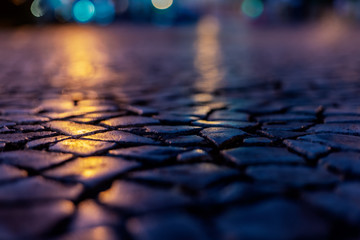 paving stones with reflection and lens flare night lights, night city abstract background and texture
