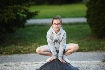 Girl child posing in a frog pose in the park. Child on the playground. Selective focus.