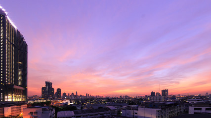 Obraz premium Panoramic cityscape skyline at twilight with modern skyscrapers under purple and pink sky background