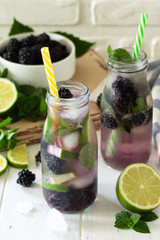 Homemade refreshing citrus lemonade mojito blackberry with  ingredients for making on wooden table.
