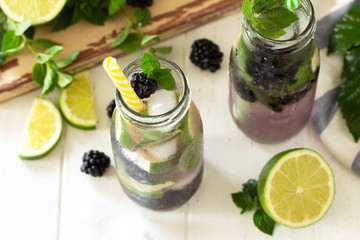 Homemade refreshing citrus lemonade mojito blackberry with  ingredients for making on wooden table.