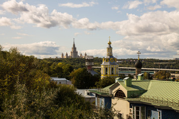 Fototapeta na wymiar panoramic view on top of the roof of the building in the foreground and sights in the distance on the background of blue cloudy sky in Moscow Russia