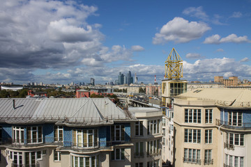 panoramic view on top of the roof of the building in the foreground and sights in the distance on the background of blue cloudy sky in Moscow Russia