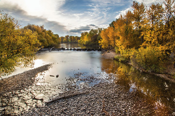 Boise river lined with colorful trees in the fall