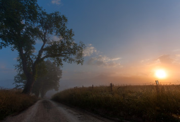 Fototapeta na wymiar Sunrise over a country road in Cades Cove, Great Smokey Mountains National Park