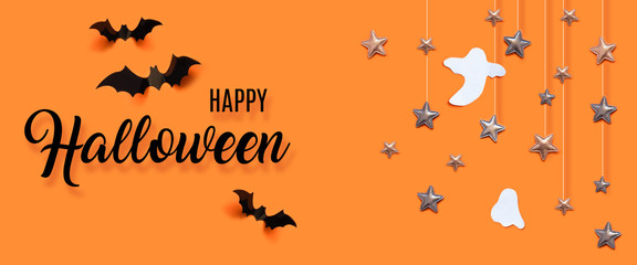 Autumn holiday composition. Halloween celebration concept with bats, ghost, spider web, stars over a orange background.