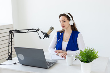Radio, blogging, podcasting concept - young woman working as a dj on the radio.