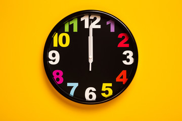 colorful wall clock show twelve o'clock