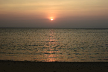 オレンジ色の夕日と水平線のはっきりした海