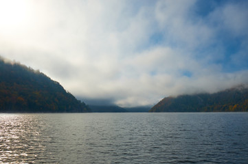 Lake in the midst of mountains and forests in fog. Altai nature