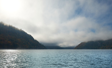 Lake in the midst of mountains and forests in fog. Altai nature