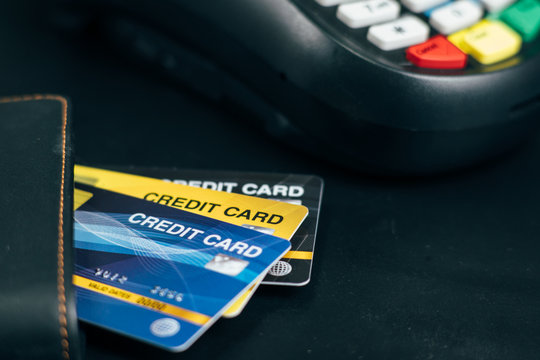 Stacked credit cards on table with Credit card reader machine or Payment terminal