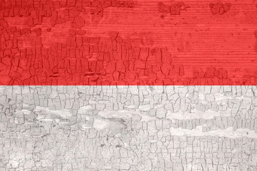 Monaco flag on an old painted tattered wooden surface.