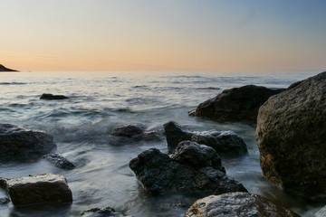 Fototapeta na wymiar rocks in a sea with sunset. longer shutter