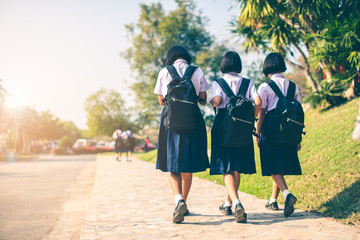 The Asian high school students in white uniform are going back home after school .