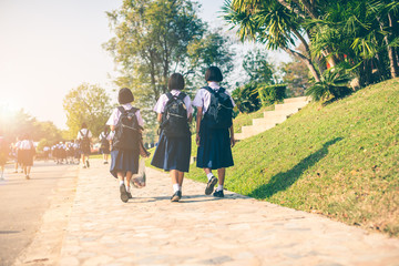 The Asian high school students in white uniform are going back home after school .