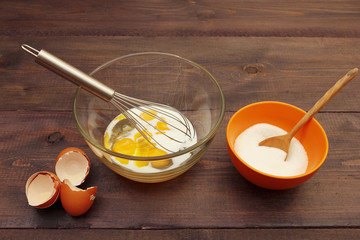 Beat eggs with milk to make dough on a rustic table.
