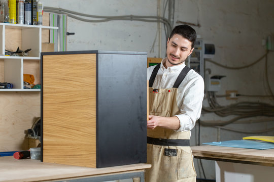 Furniture factory and small and medium sized enterprises concept - Man collects furniture details