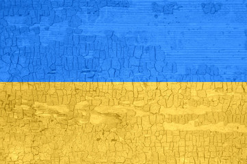 Ukraine flag on an old painted tattered wooden surface.