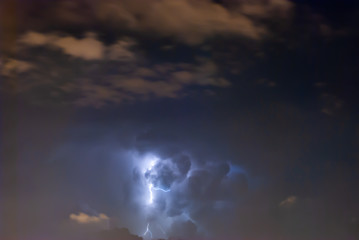 Powerful Lightning bolts strike in the stormy weather sky.