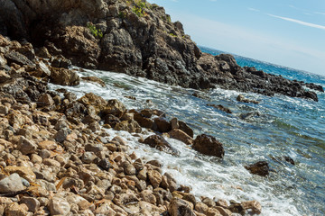 Seascape: rocky shore, stones, turquoise water, blue sky. Krk, island of Krk, Croatia.