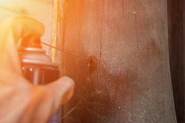 Spray insecticide into the hole with sun flare, soft focus, noise