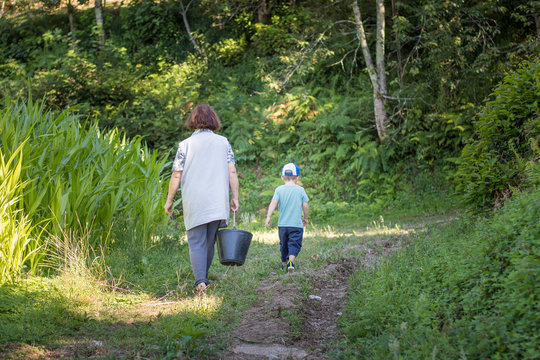 Grandmother and grandson walking in the park, Excercise exchange and intergenerational relationship.