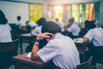 Asian high school students in a white school uniform are serious and tired of exams.