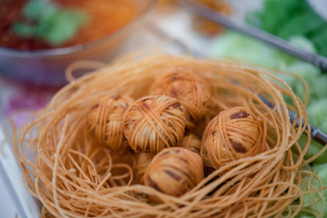 "Moo Sarong" is Thai traditional snack made with minced pork, mixed with coriander root, pepper, fish sauce, garlic ,Chinese yellow noodle fried to eaten with dipping sauce.