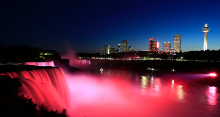 Fototapeta na wymiar Niagara Falls at dusk including the skyline of the Canadian city of the background
