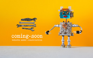 Web site under construction Coming Soon template page. Toy robot looks at a set of hand wrenches...