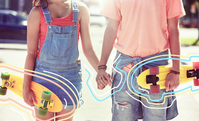 summer, relations, extreme sport and people concept - close up of happy teenage couple with short modern cruiser skateboards on city street with glowing lines