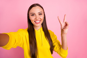 Self portrait of attractive cute gorgeous fascinating pretty cute nice kind friendly girlfriend taking selfie showing v-sign wearing yellow sweater hoodie isolated over pastel color background