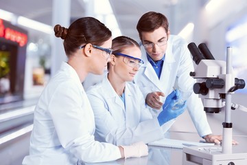 Female and male scientists in glasses working with microscope