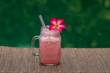 Grapefruit pink shake or smoothie on the table, close up. Breakfast in island Bali, Indonesia
