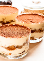 Tiramisu in the glass decorated whith mint on the wooden background
