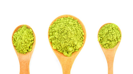 powdered matcha green tea in wooden spoon isolated on white background